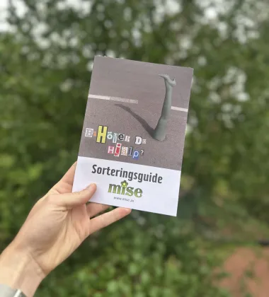Mises broschyr mot grönskande bakgrund 