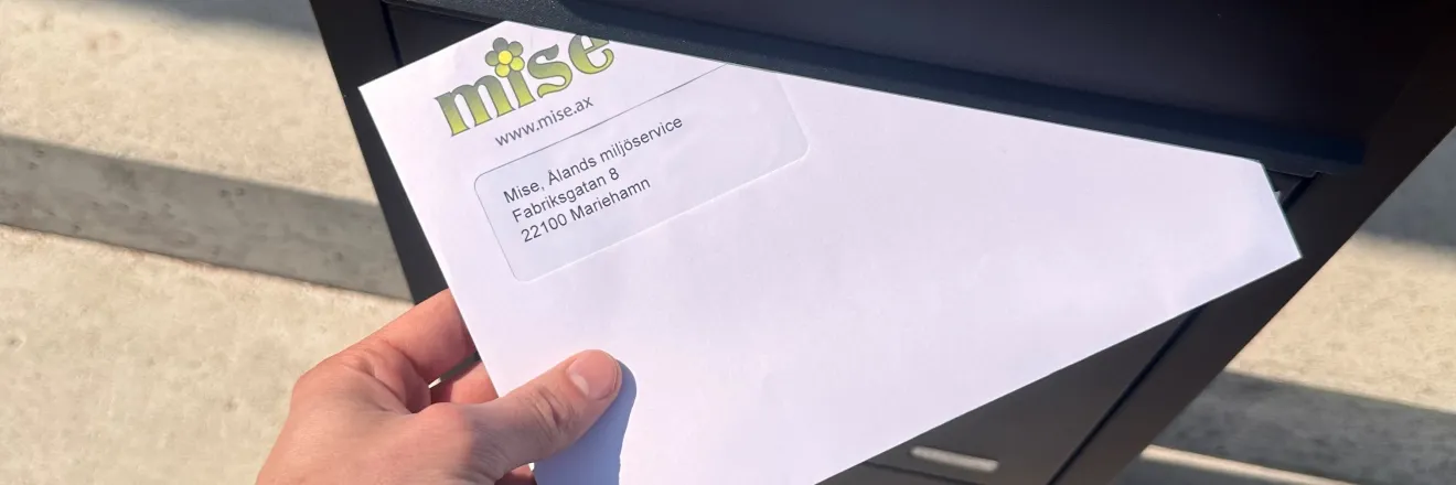 misefaktura som postas i en postlåda av en hand 